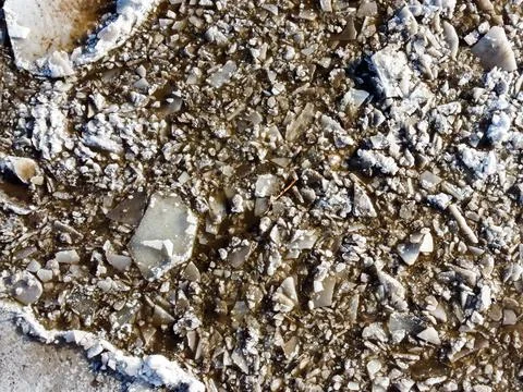 Abstract texture of broken white ice and dark water at winter. Spring is coming. Stock Photos