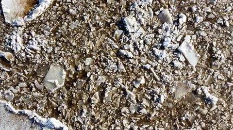 Abstract texture of broken white ice and dark water at winter. Spring is coming. Stock Photos