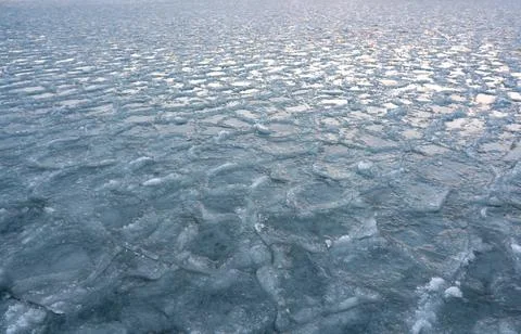 Abstract texture of broken white ice and dark blue water. View of the ice fro Stockfoto's