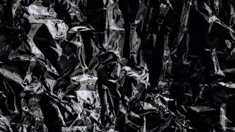 Abstract texture of crumpled black plastic foil, animated background Video stock 333977578