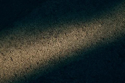 Abstract texture of rough asphalt road surface with a sharp diagonal beam o.. Stock Photos