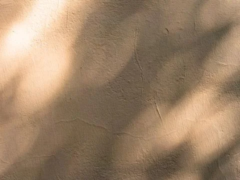 Abstract texture of a shadow on a beige weathered and cracked wall Stock Photos