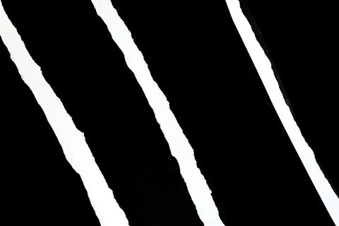 Abstract texture of torn paper with black and white diagonal stripes. Stock Photos