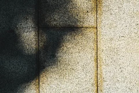 Abstract textured stone wall with light and shadow patterns creating artist.. Stock Photos