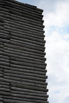 Abstract textured wall made of stacked log cross-sections. Stock Photos