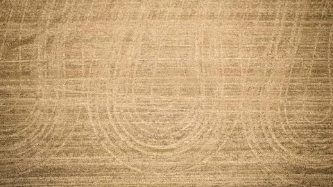 Abstract three tire track swooshing lines of empty farm field after harvest Stock Photos