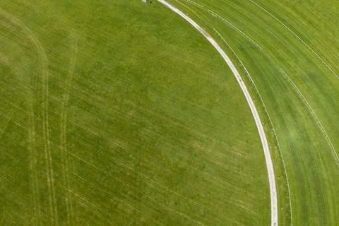 Abstract top down aerial drone view of the curved grass racing track and pa.. Stock Photos