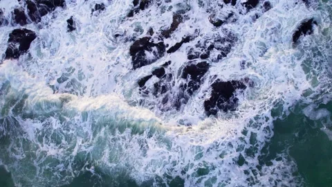 Abstract top down foamy ocean waves crashes rock Stock Footage 220833401