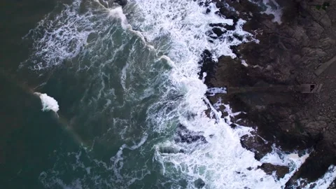 Abstract top down foamy ocean waves crashes rock Stock Footage 220833572
