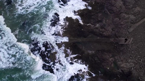 Abstract top down foamy ocean waves crashes rock Stock Footage 222047392