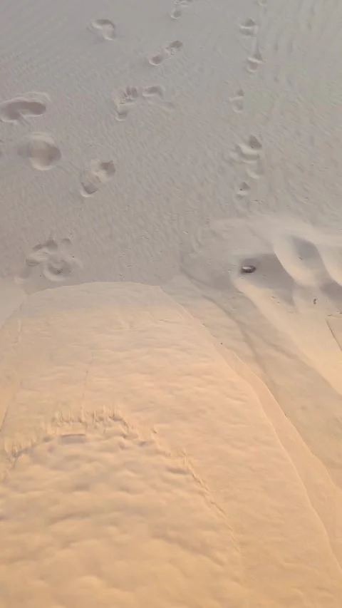 Abstract top view of human footprints on a golden sand dune texture. Stock Footage 312898134