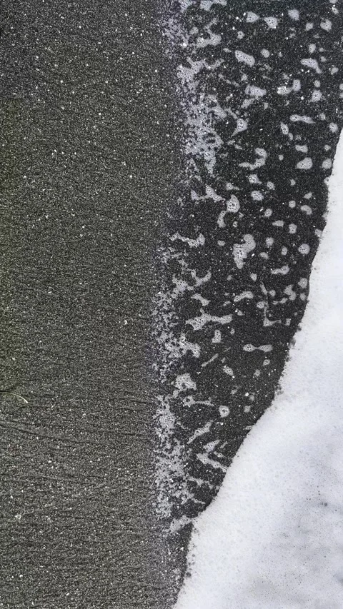 Abstract top view of wave retreating on dark shore Video stock 344536942