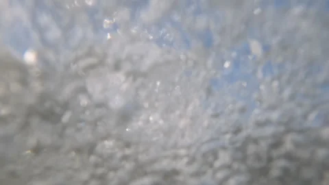 Abstract underwater close-up of bubbles and light beneath a splashing water Stock Footage 344829104