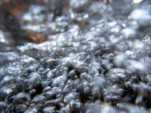 Abstract underwater image of streaming bubbles over colorful stones on riverbed Foto stock