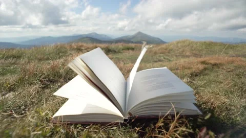 Abstract video of book pages being closed by the wind in the mountains. Stock Footage 214325969