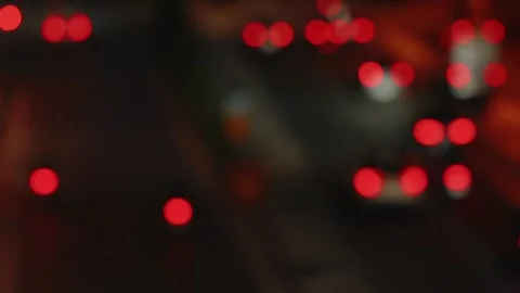 Abstract view of blurred red tail lights from moving traffic on a night city Stock Footage 309443335