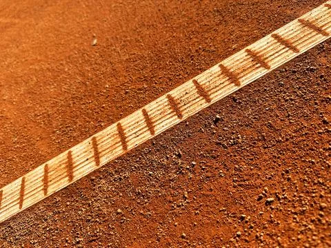 Abstract view of diagonal white line on orange clay tennis court Stock Photos