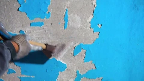 Abstract view of peeling blue paint on a textured wall being cleaned by a scr 库存影片 333532078