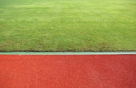 Abstract view of running track and green field Stock Photos
