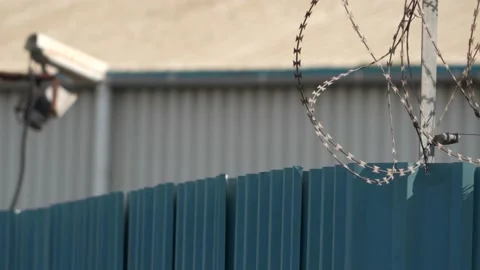 Abstract view of a security camera and razor wire fence Video stock 217430974