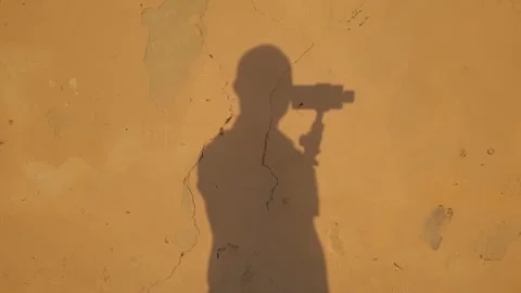 Abstract view of shadow of man holding gimbal on yellow cracked wall, pan Stock Footage 279907590