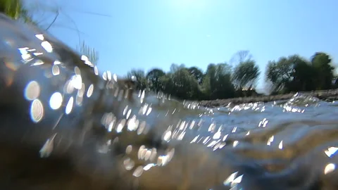 Abstract view of surface of flowing river with bokeh white spots from glare Stock Footage 145452350