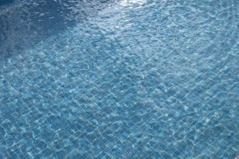 Abstract view of a swimming pool with rippling water and sunlight reflections Stock Photos