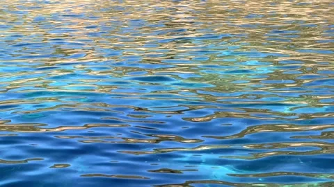 Abstract view of vibrant blue and golden reflections shimmering on the rippled w Stock Footage 318711223