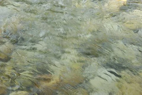 Abstract Water Background in Motion, River Stones Under Clear Flow Stock Photos
