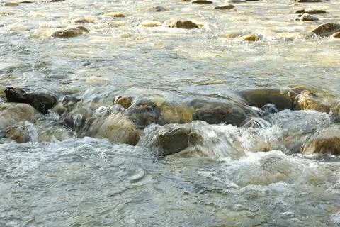 Abstract Water Background in Motion, River Stones Under Clear Flow Stock Photos