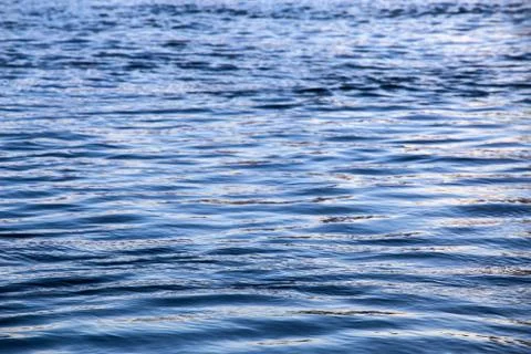 Abstract water surface closeup with small plain ripples and selective focus Stock Photos