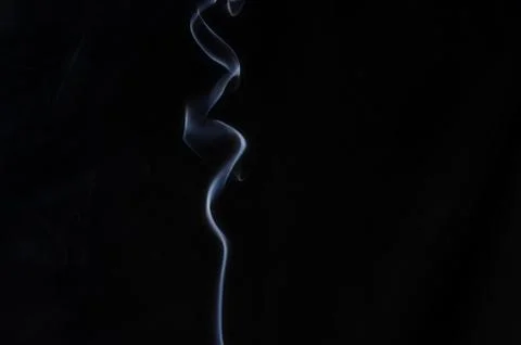 Abstract wave shape made of smoke in the center of the frame on a dark backgr Stock Photos