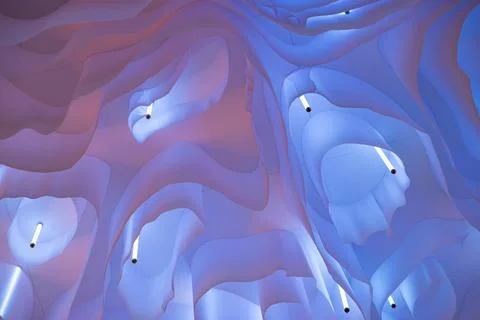 Abstract wavy fabric structure creating a glowing ethereal ceiling design 库存照片
