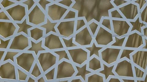 Abstract white geometric star pattern on yellow wall exhibits the islamic art Stock Photos