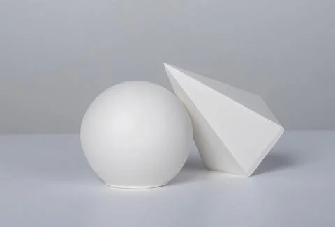 Abstract white plaster sphere, pyramid casting soft shadow on clean backgroun Stock Photos