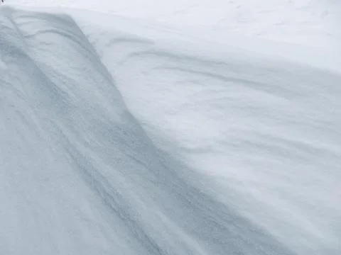 Abstract white snow texture with wind-blown ripples and soft shadows Stockfoto's