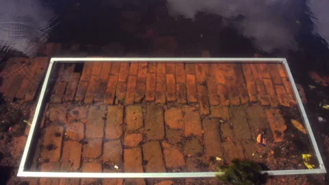 An abstract wide shot of a frame lying on water over bricks. Vídeo Stock 167107319