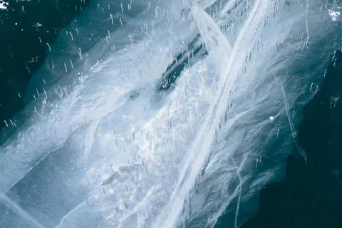 Abstract winter ice texture with cracks and bubbles on Lake Baikal surface Stock Photos