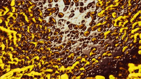 Abstract yellow drops of paint move and spread Stock Footage 134327343