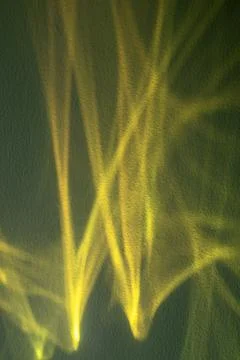 Abstract yellow light patterns on a green wall, a vibrant and dynamic background Stock Photos