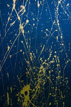 Abstract yellow paint splashes, element of creative graffiti on a bright blue Stock Photos