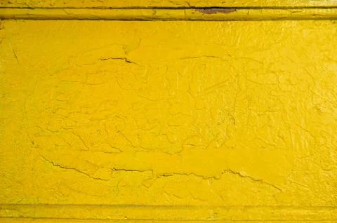 Abstract yellow solid background with cracks in the paint. Texture. Stock Photos