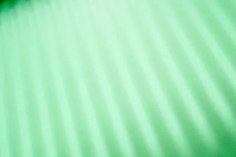 Abstraction created by the straight shadows of a grid on a green surface. 스톡 사진