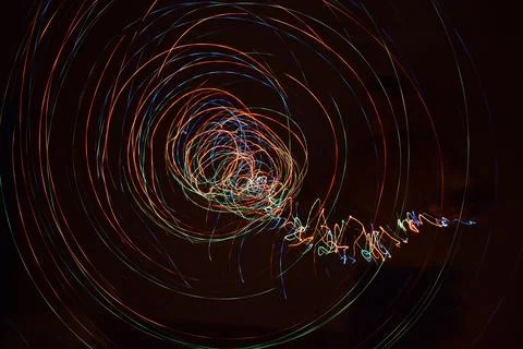 Abstraction formed by traces of circular motion of light sources in the dark. Stock Photos
