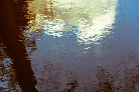 Abstraction. The reflection in the water of the sky and trees. Stock Photos