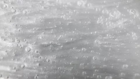 Abstraction of the silver shiny viscous fluid with a lot of bubbles and small Stock Footage 249333751