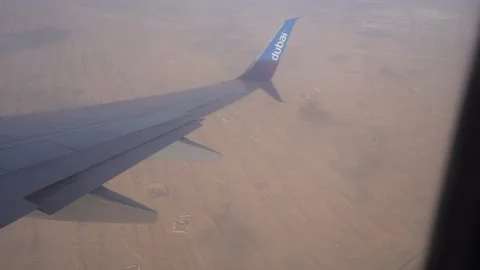 Abu Dhabi, UAE - January 18, 2026: Airplane wing over desert landscape with 库存影片 328916533