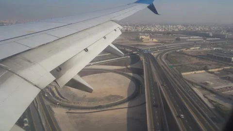Abu Dhabi, UAE - January 18, 2026: Airplane wing descending over cityscape Stock-Footage 328916655