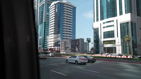 Abu Dhabi, UAE - January 18, 2026: City traffic flows past modern skyscrapers in Vídeos de archivo 328916749