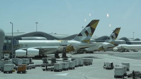 Abu Dhabi, UAE - May 15, 2024 - Etihad Airways Airbus A380s parked at AUH Stock Footage 290777234